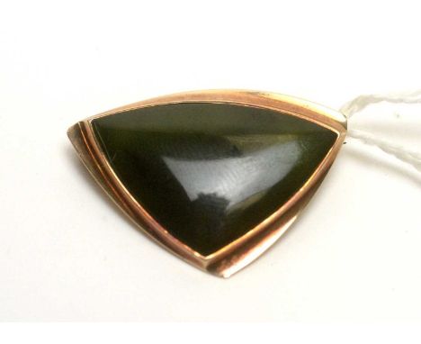 A modern abstract spinach jade cabochon and yellow-metal brooch, stamped 9ct, 8.3g gross.