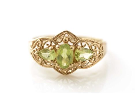 A three stone peridot ring, in 9ct yellow gold mount and shank, ring size L.