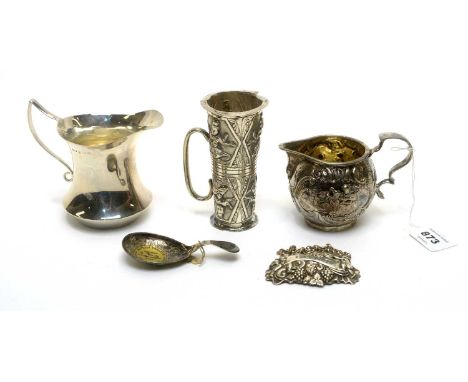 A silver cream jug; a Dutch silver jug with import marks; an Indian silver licqure measure; a silver caddy spoon; and a silve