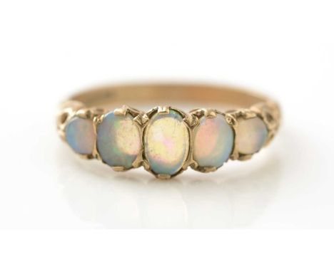 A five stone opal ring, the graduated oval opal cabochons in 9ct yellow gold scrolling mount and shank, ring size N.