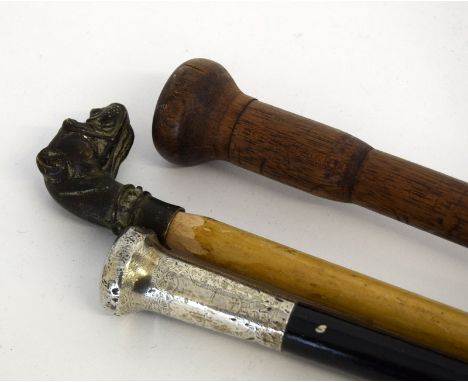 A bronze dog head walking stick, a silver topped walking stick, a pick up stick and one other