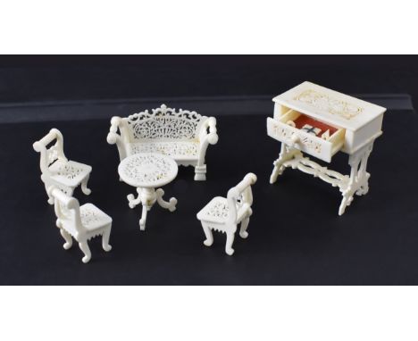 {Miniatur-Salongarnitur:} Sofa, drei Stühle, Tisch und Nähkästchen. Beinschnitzerei. Ende 19. Jh. Sofa L 5 cm