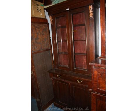 A Victorian Mahogany Bookcase on Cupboard, having moulded cornice over a pair of opposing single pane glazed doors opening to