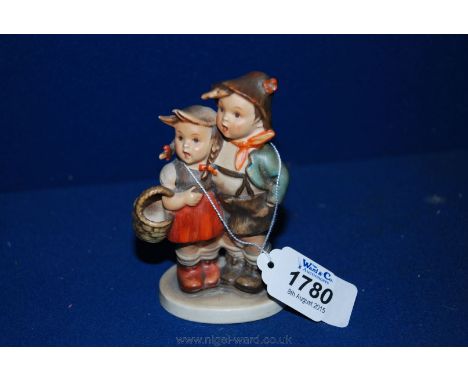 A Goebel ornament of two young children, the girl carrying a basket.