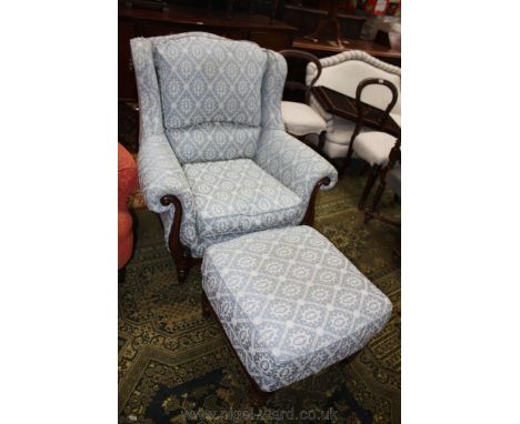 A modern show frame light blue and cream fabric upholstered wing back Fireside Armchair with swept and carved arm supports an