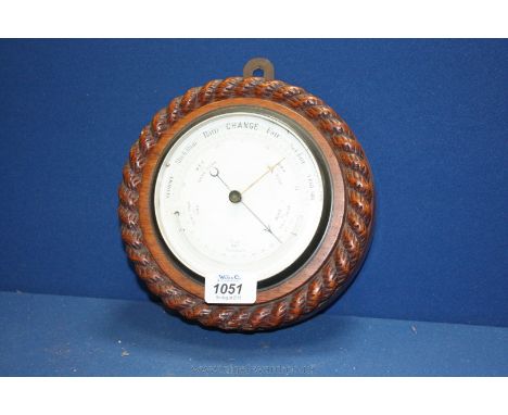 A circular Barometer in a heavy carved wood surround, 8'' diameter.