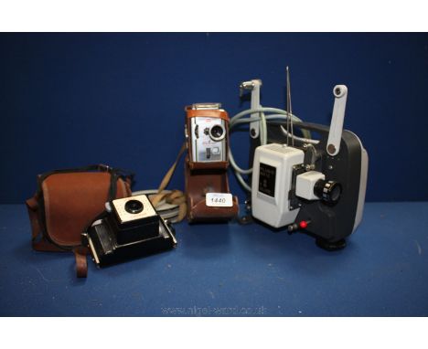 A Coronet Camera with case, a Kodak Brownie 8 mm movie Camera and a Plus-o-matic movie Projector with reels.