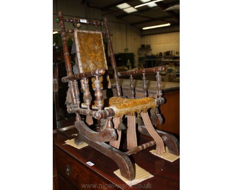 A 19th c. child's American Rocking Chair with beech spindle turned frame and mustard carpet style fabric to pad back and seat