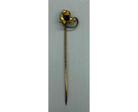 A 9ct gold floral design tie pin with single set red stone (approx total weight 0.8g)