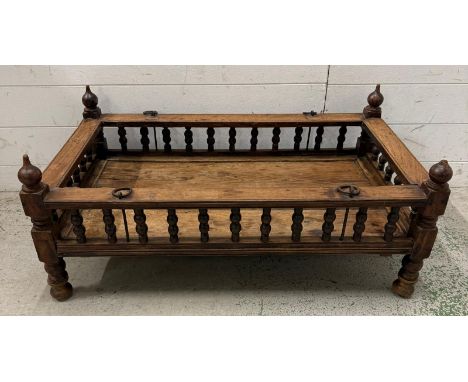 A vintage Indian cot with a hand turned spindle balustrade and slated base (H37cm W87cm D52cm)