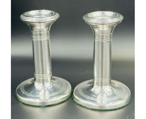 A pair of squat silver candlesticks by Mappin & Webb hallmarked for Birmingham 1909.
