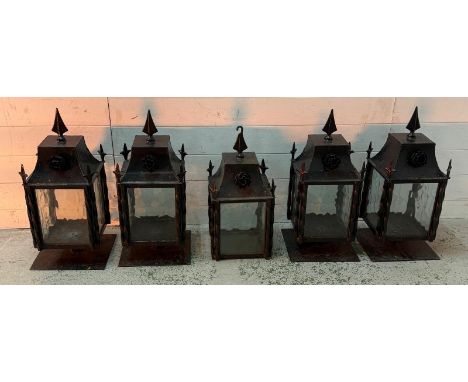 Four wrought iron coach house wall mounted lanterns and one matching wall hanging lantern 