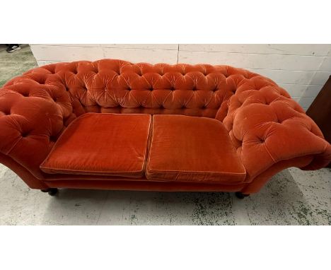 A Chesterfield style two seater sofa in orange fabric on turned legs (W196cm D96cm SH40cm)
