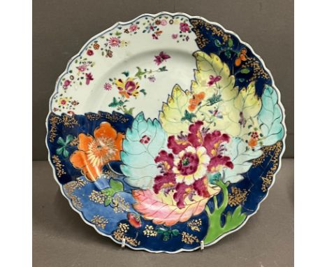 A Chinese export "Tobacco Leaf" pattern plate, painted with large lotus flowers and other blossoms, the reverse in iron red a
