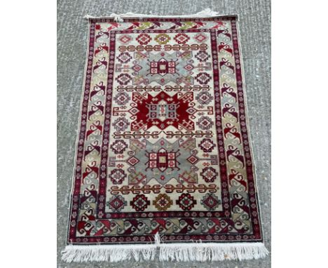 A wool prayer mat or small rug, beige ground with a red geometric border 157cm x 103cm  Condition Report  some wear otherwise
