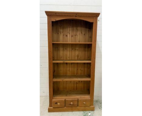 A three shelf pine bookcase with three short drawers under (H180cm W92cm D35cm)