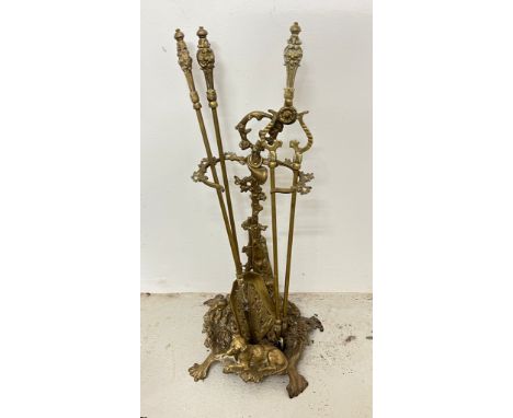 A brass fire companion stand and fire irons featuring a hunting theme 
