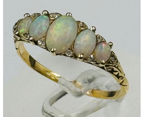 An opal and diamond set ring, set with five oval cabochon cut opals, measuring between 7.4mm x 5.17mm and 4mm x 3mm, interspe
