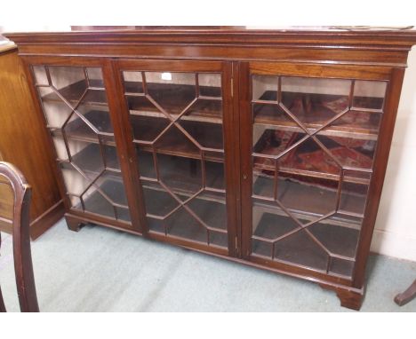 A three door glazed bookcase on bracket feet, 114cm high x 170cm wide x 44cm deep Condition Report: Available upon request