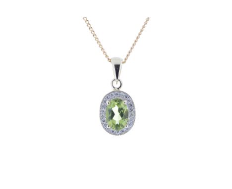 An oval peridot 0.75 carats is nested amongst a halo of round brilliant cut diamonds in this vintage style 9ct yellow gold pe