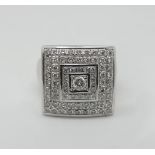 1 Damenring WG 18ct. mit Brillanten zentral wohl ca. 0,15ct. und dreifachem viereckigem Brillantkran