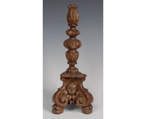 An 18th century giltwood candlestick base, knopped stem carved with acanthus, the tri-form base with putto masks, 39cm high, 