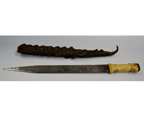 A Persian knife,the blade engraved strapwork and script, bone handle, crocodile scabbard, 56cm long