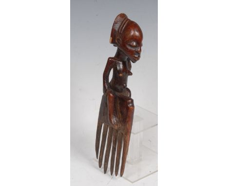Tribal Art - a Luba comb, carved as a female figure seated astride a six-prong lower section, 27cm high, Congo 