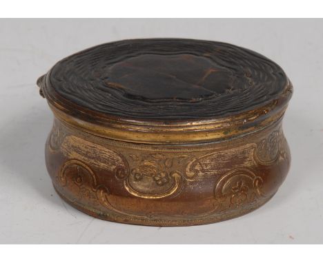 An 18th century pressed tortoiseshell and gilt metal waisted circular snuff box, the side chased with flowers and C-scrolls, 