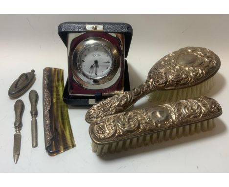 Silver - an R J Carr silver cased traveling alarm clock, Sheffield 2001 ;  a three piece dressing table set, Birmingham 1996;