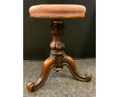 A Victorian carved mahogany piano stool, upholstered revolving top, carved bulbous column, shaped tripod legs, 47cm high 