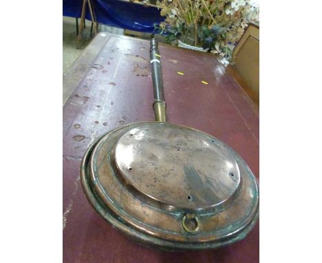 A copper bed warming pan