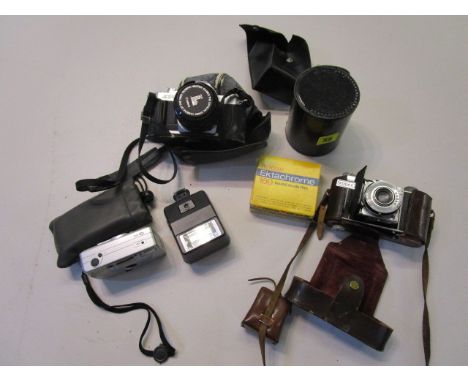 A group of vintage cameras, lens and accessories t include a Canon AV-1 camera