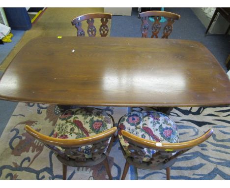 An Ercol trestle end dining table, 28 x 60 x 30 and four chairs with Prince of Wales feathers, pierced backs and loose cushio