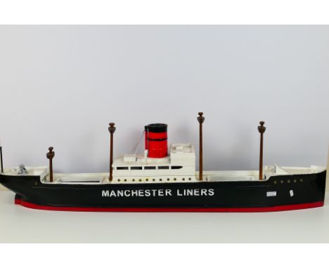 A wooden model possibly scratch built, of a ship named 'Manchester Liners' measures approximately 130cms (L) x 17cms (W) x 38