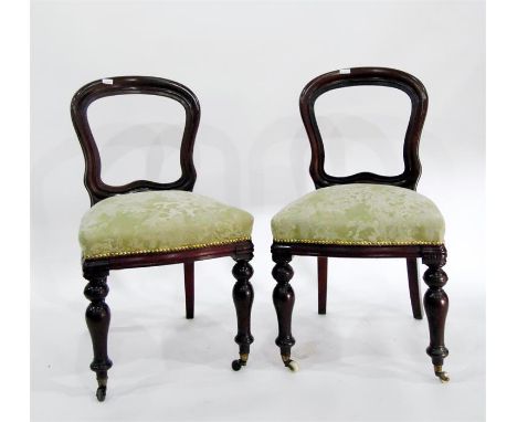Set of four late 19th century mahogany balloon-back dining chairs with sprung seats, turned front supports with ceramic casto