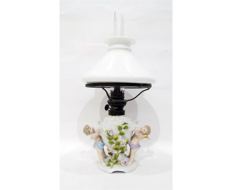 German porcelain oil lamp base of shell-shaped form, flower encrusted, supported by cherubs together with the opaque shade, c