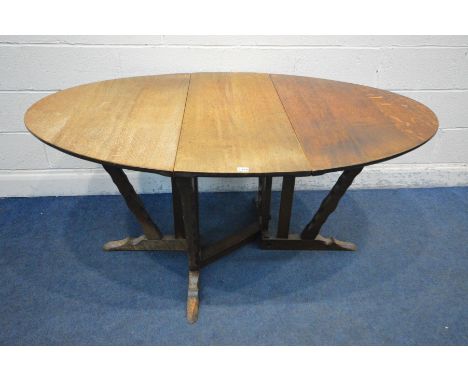 IN THE MANNER OF ARTHUR ROMNEY GREEN (c1872-1945) AN OAK ARTS AND CRAFTS GATE LEG TABLE, oval top, detailed chamfered support