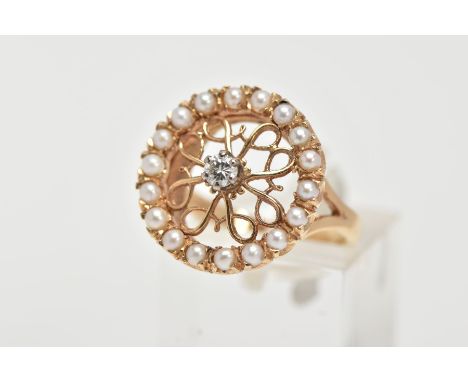 A 14CT GOLD DIAMOND AND SEED PEARL RING, of a circular form, centring on a raised and claw set, round brilliant cut diamond, 