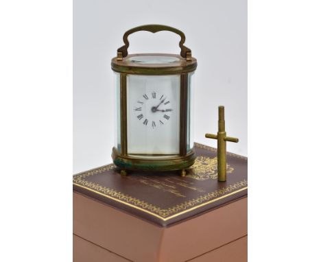 A MINIATURE BRASS, FIVE GLASS OVAL CARRIAGE CLOCK, French mechanical key wound movement, enamel white dial, Roman numerals, b