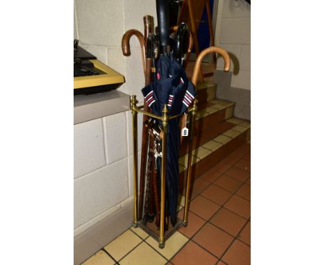 A MODERN BRASS STICK STAND, containing a quantity of wooden walking sticks and umbrellas, height of stand approximately 68cm