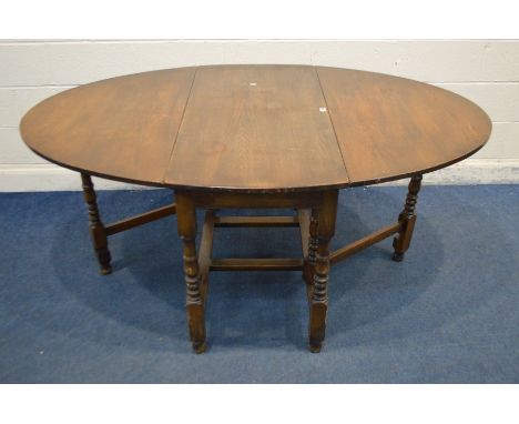 A MID TO LATE 20TH CENTURY OAK OVAL GATE LEG TABLE, open length 179cm x depth 121cm x closed length 61cm (minor water damage 