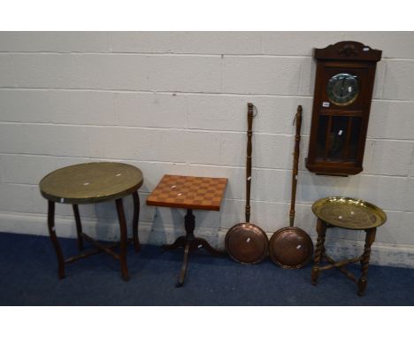 AN EARLY 20TH CENTURY OAK WALL CLOCK (pendulum and winding key) together with two brass topped folding occasional tables, a m