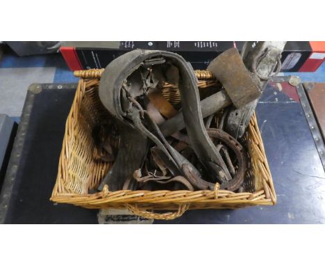 A Wicker Basket Containing Leather Harness, Hand Axe, Horse Shoe etc 