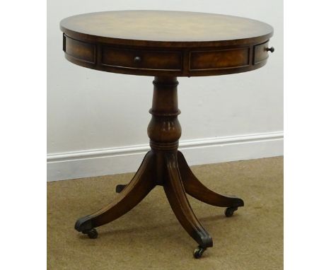 Regency style walnut drum table, two frieze drawers, single turned column on four sabre supports, brass capped with castors, 