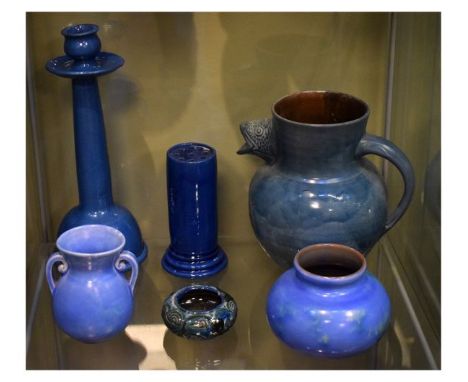 Six items of C.H. Brannam (Barnstaple) pottery comprising: hat pin holder, candlestick, jug with fish spout, small pot and tw