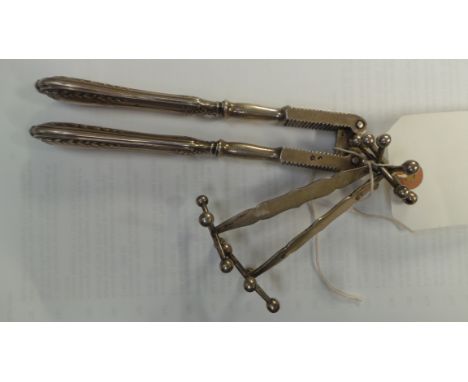 A pair of continental silver knife rests together with a French nut cracker