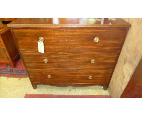 A Georgian mahogany chest of three graduated drawers raised on shaped bracket supports with brass handles