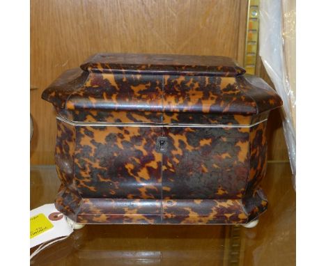 A Regency tortoiseshell tea caddy of sarcophagus form on ivory feet