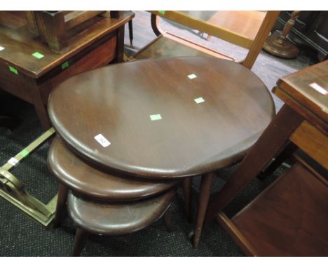 A nest of three dark stained Ercol style tables